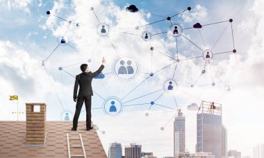 Delikanlı çatıda dikiliyor ve bağlantı hatları çiziyor. Karışık ortam