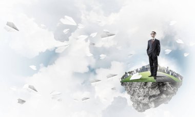 Mavi gök yeşil yüzen ada üzerinde duran zarif emin iş adamı