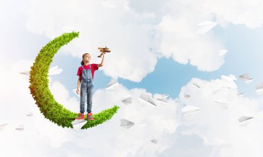 Yeşil Ay 'da durup uçak oyuncağıyla oynayan tatlı kız.