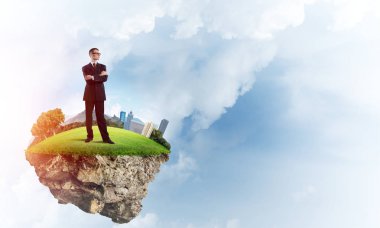 Mavi gök yeşil yüzen ada üzerinde duran zarif emin iş adamı