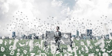 Kırmızı gözlüklü ve takım elbiseli komik adam bankta oturup kitap okuyor.