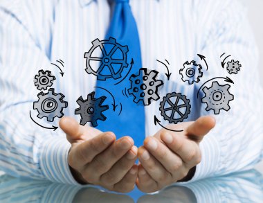 Masada oturan ve dişli mekanizması avuç içi gösterilen işadamı yakın çekim