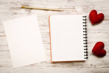 Kalpler ve ahşap masa üzerinde boş not defteri.