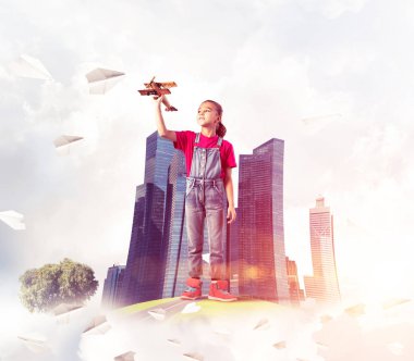 Şehrin yüzen adasında eski model uçaklarla oynayan tatlı bir kız.