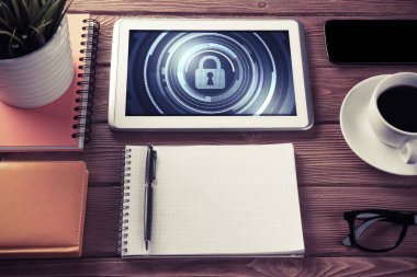 Ofis eşyalarıyla iş yeri ve ekranda asma kilit simgeleri olan tablet