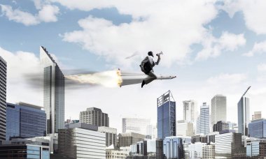 Arka plan üzerinde modern cityscape gökdelenler ve mavi gökyüzü ile roket üzerinde uçan takım elbiseli genç işadamı kavramsal görüntü.