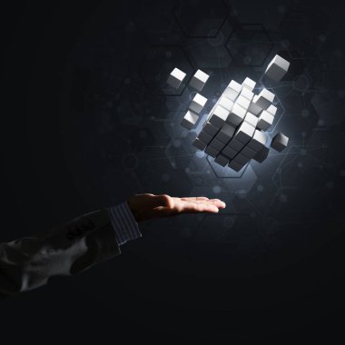 Küp şekil yenilik, karışık teknik sembolü olarak tutan işadamı el ile kapatın