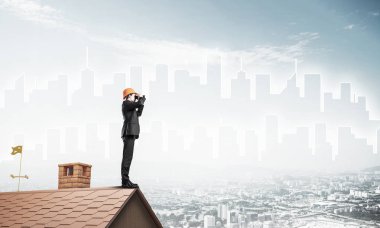 Takım elbiseli ve miğferli genç işadamı yeni bir şey arıyor. Karışık ortam