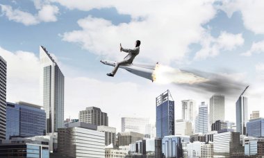 Arka plan üzerinde modern cityscape gökdelenler ve mavi gökyüzü ile roket üzerinde uçan takım elbiseli genç işadamı kavramsal görüntü.