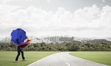 Sırtında kağıt top taşıyan inşaatçı.