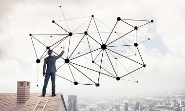 Delikanlı çatıda dikiliyor ve bağlantı hatları çiziyor. Karışık ortam