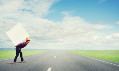 Adam büyük kutusunu sırtında taşıyor.