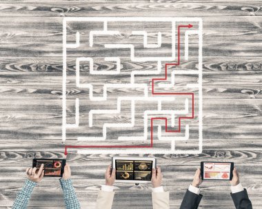 Elinde cihazlar olan bir grup insan doğru çözümü bulmak için birlikte çalışıyor.