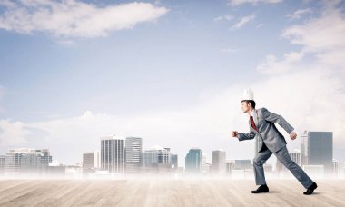 Beyaz taçlı yakışıklı iş adamı aceleyle koşuyor.