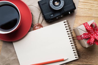 Not defteri kahve Kupası ve ahşap masa üzerinde eski fotoğraf makinesi