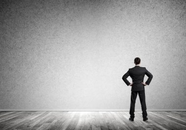 Boş beton odada kendine güvenen zarif iş adamının arka planı