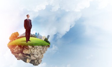 Mavi gök yeşil yüzen ada üzerinde duran zarif emin iş adamı