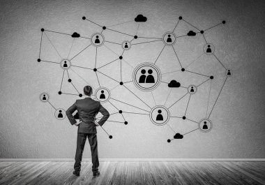 Arkadan görünüşü çizilmiş sosyal bağlantı kavramı ile duvara bakarak işadamı