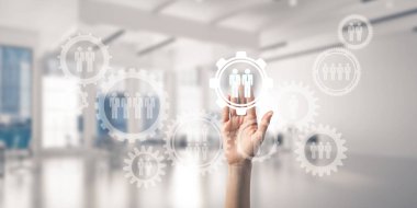 Kadın elinin perdede, arka planda avuç içi ve ofis olan dişlilere dokunuşunu kapat