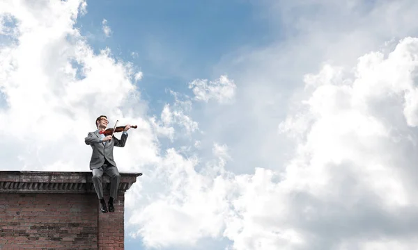 Joven Vestido Traje Gafas Sentado Techo Tocando Violín —  Fotos de Stock