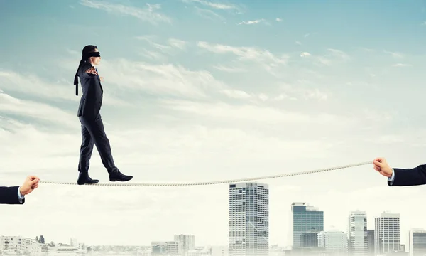 都市の背景にロープを歩いて目に目隠しをしているビジネスマン — ストック写真