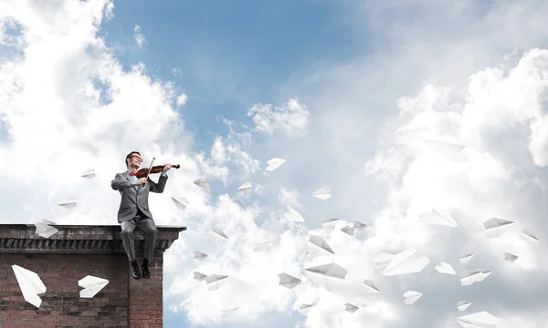 Joven Vestido Traje Gafas Sentado Techo Tocando Violín —  Fotos de Stock