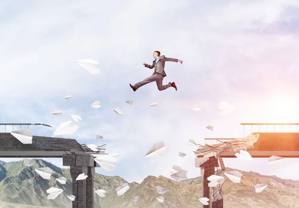 Geschäftsmann Springt Über Brücke Zwischen Fliegenden Papierflugzeugen Als Symbol Für — Stockfoto