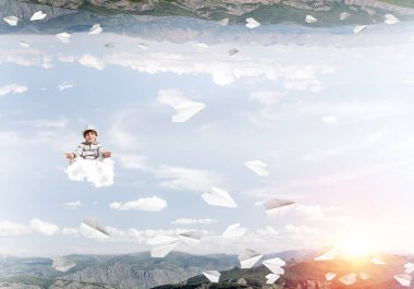 Genç küçük çocuk gözleri koruma kapalı ve seyir bulut uçan kağıt uçaklar arasında ve doğa dünyalar arasında üzerinde meditasyon sırasında konsantre.