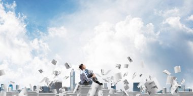 İş adamı uzak belgeler kağıtları Clear sky ile arka plan üzerinde uçan arasında yığını üzerinde otururken arıyorum. Karışık teknik.