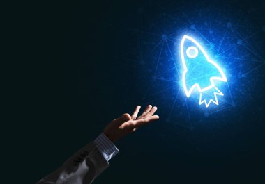 Koyu arkaplanda parlayan roket simgesi ve iş adamı eli