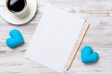 Kahve fincanı not defteri kalem ve ahşap yüzeyde iki kalp