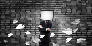 Arka plan üzerinde duran kağıt uçak uçan arasında ve gri karanlık duvara işadamı Tv ile takım baş silah tutmak yerine geçti.