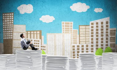 Düşünceli işadamı uzakta ile arka plan üzerinde çizilmiş cityscape belgeleri yığını üzerinde otururken arıyorum. Karışık teknik.