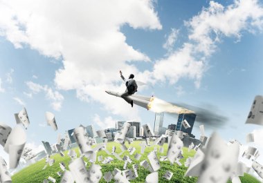 Kağıtları cityscape ve mavi gökyüzü ile arka plan üzerinde uçan arasında roket üzerinde uçan takım elbiseli genç işadamı kavramsal görüntü.