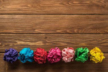 Yeni fikirlerin arama aracı olarak ahşap tablo satırında birden çok renkli crampled kağıt topu kümesi yerleştirilir.