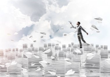 Arka plan üzerinde Clear gökyüzü ile rahat kıyafet kağıt uçan arasında duran el kitabı ile uydurarak erkekte uçakları. Karışık teknik.