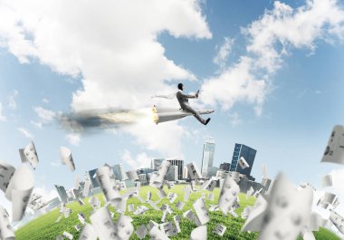 Kağıtları cityscape ve mavi gökyüzü ile arka plan üzerinde uçan arasında roket üzerinde uçan takım elbiseli genç işadamı kavramsal görüntü.