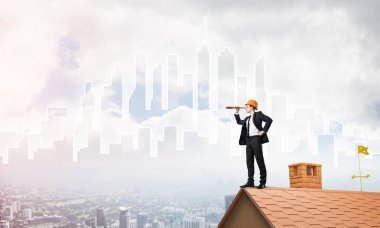 Takım elbiseli genç işadamı ve çatıda kask var. Karışık ortam