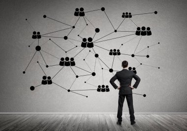 Arkadan görünüşü çizilmiş sosyal bağlantı kavramı ile duvara bakarak işadamı