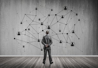 Arkadan görünüşü çizilmiş sosyal bağlantı kavramı ile duvara bakarak işadamı