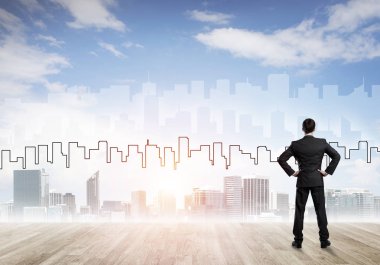 İşadamı arkasını dönüp modern iş merkezinin siluetine bakıyor.