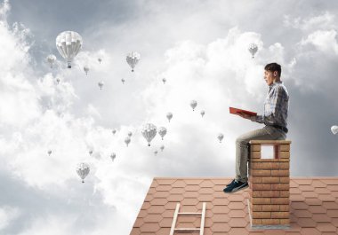 Elinde kırmızı kitap ile evin baca rahat oturan genç adam