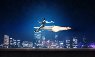 Arka plan üzerinde gece cityscape ve mavi gökyüzü ile roket üzerinde uçan takım elbiseli genç işadamı kavramsal görüntü.