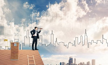 Çatıda takım elbiseli genç bir işadamı var. Karışık ortam