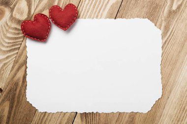 Sevgi kalpleri ve ahşap masa üzerinde boş kağıt