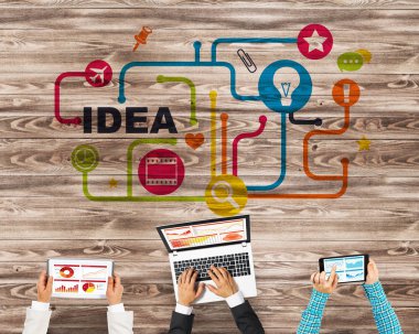 Ellerinde cihazlar bulunan üç kişilik bir grup iletişim ve ağ oluşturma sembolü olarak birlikte çalışıyor.