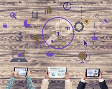 Ellerinde cihazlar bulunan üç kişilik bir grup iletişim ve ağ oluşturma sembolü olarak birlikte çalışıyor.