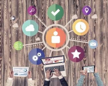 Ellerinde cihazlar bulunan üç kişilik bir grup iletişim ve ağ oluşturma sembolü olarak birlikte çalışıyor.