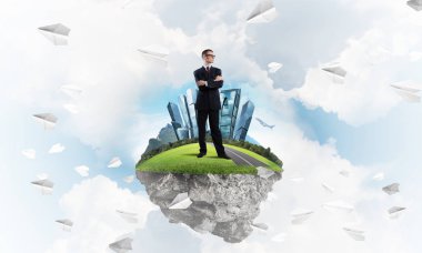 Mavi gök yeşil yüzen ada üzerinde duran zarif emin iş adamı