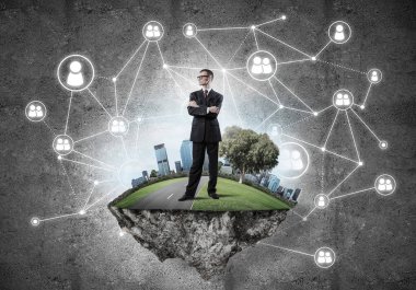 Uçan yeşil adada beton zeminde zarif bir işadamı.